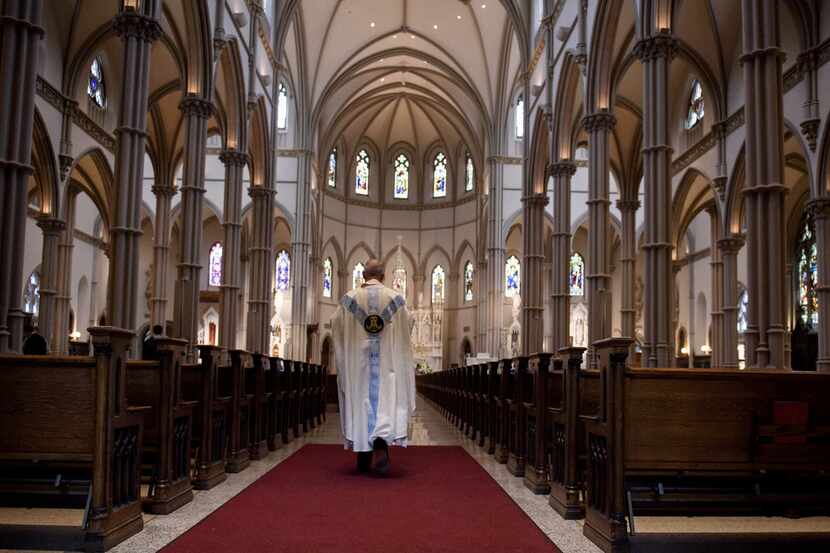 Father Kris Stubna walks through the sanctuary after a recent Mass to celebrate the...