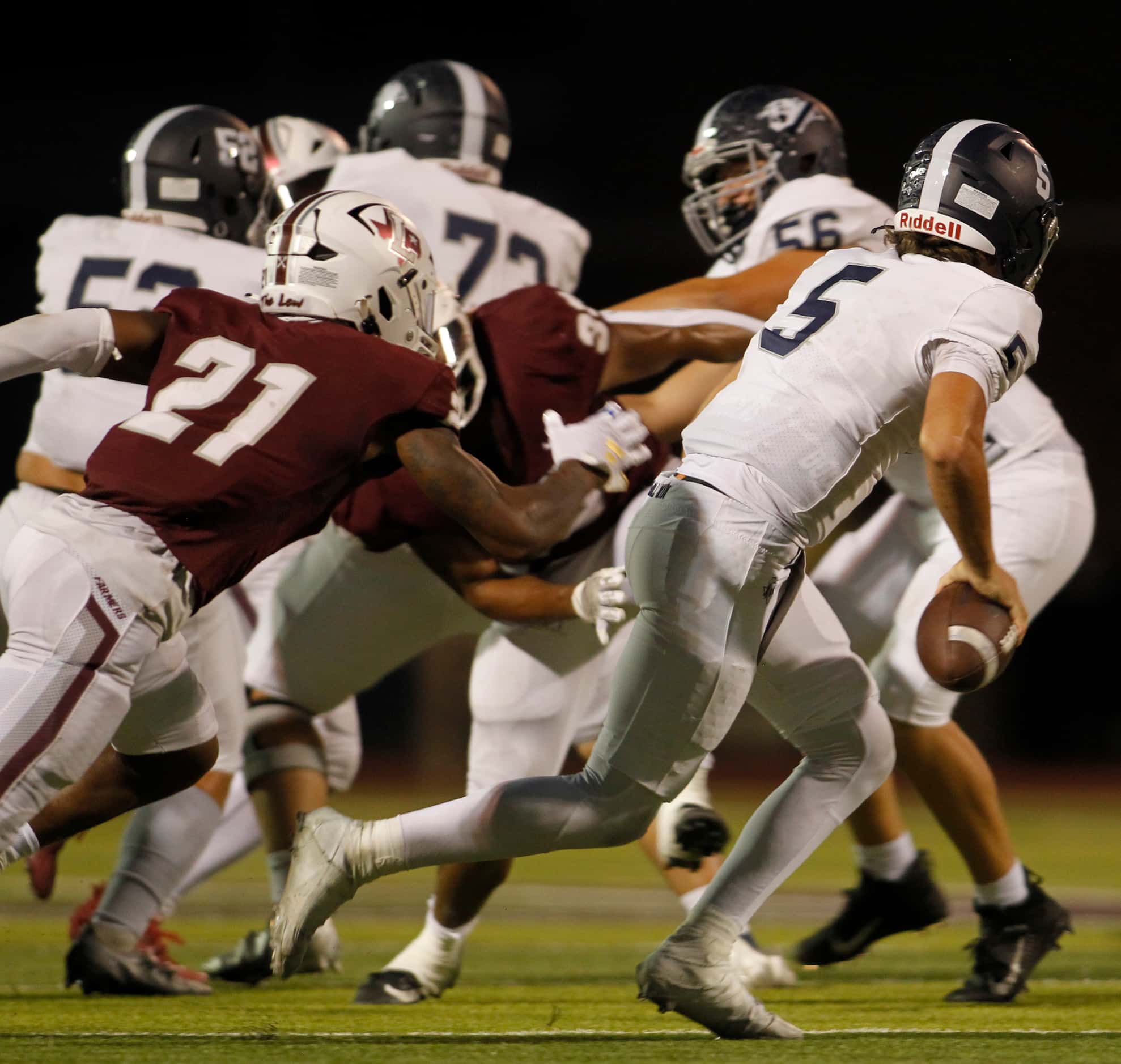 Flower Mound quarterback Jake Watson (5) rolls out of the pocket to avoid the defensive...