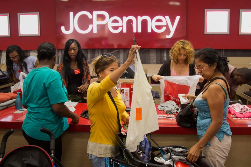 Employees assist customers at the checkout counter of a J.C. Penney Co. in the Brooklyn...