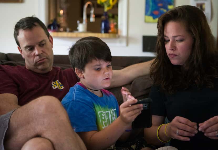 Marilyn Morrison, 9, explains to her parents, Andrew and Chelsa, how to use a function on a...