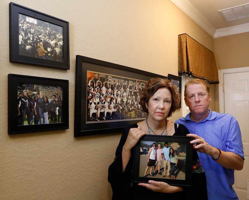 Lisa and Dave Stephenson hold a photograph of them with Thomas Johnson and Maria Paula in...
