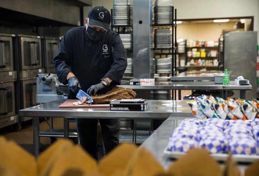 John Gilbert, owner of G-Texas Custom Catering, slices brisket for box lunches for Austin...