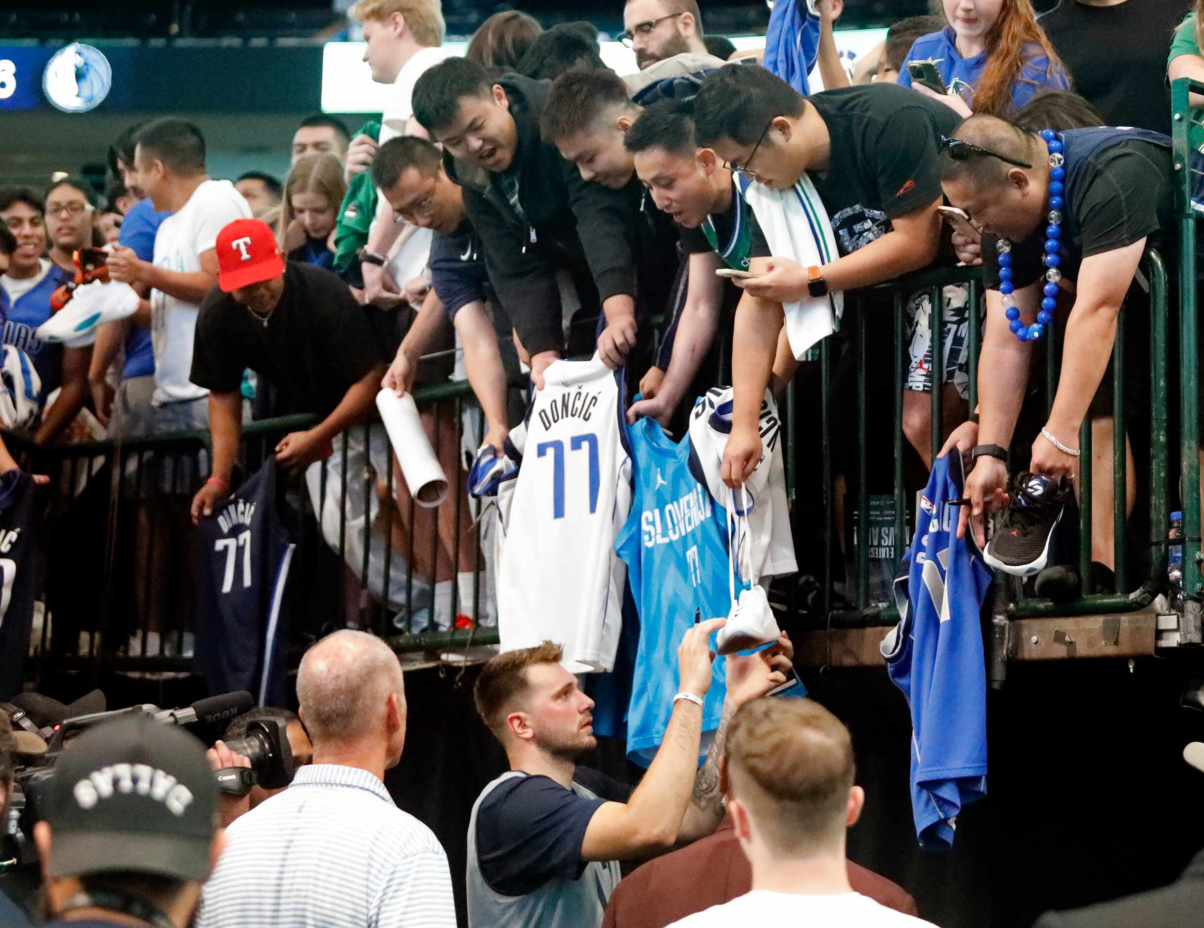 Dallas Mavericks guard Luka Doncic (77) prepares to autograph a shoe after the game at the...