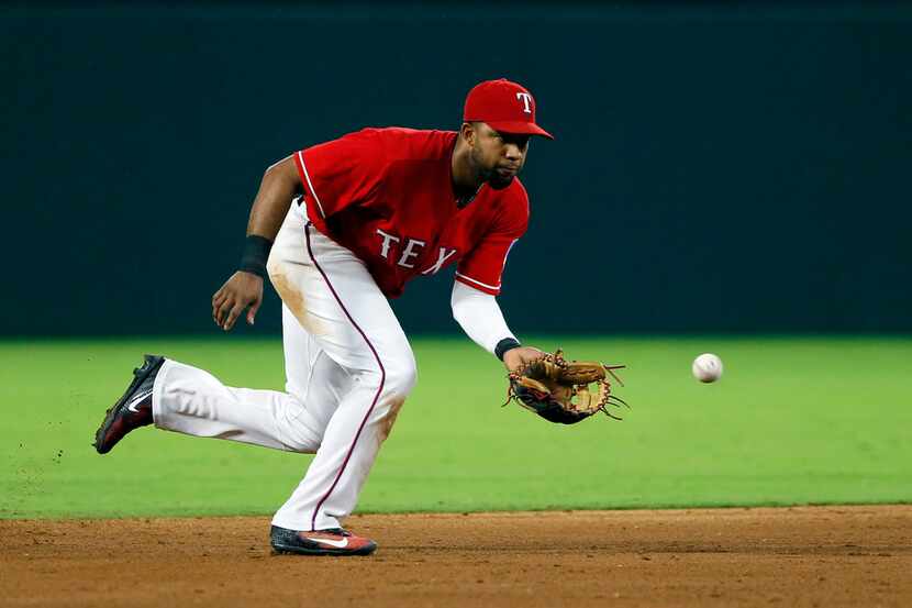 Texas Rangers shortstop Elvis Andrus reaches down to field a ground out by Oakland...