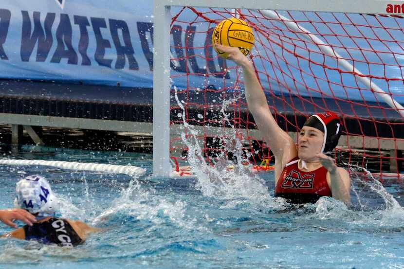 Flower Mound Marcus high school goalie Emily Engberson, right, tries to block a shot as...