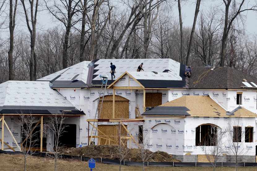 Workers install a roof on a new home in Pepper Pike, Ohio.