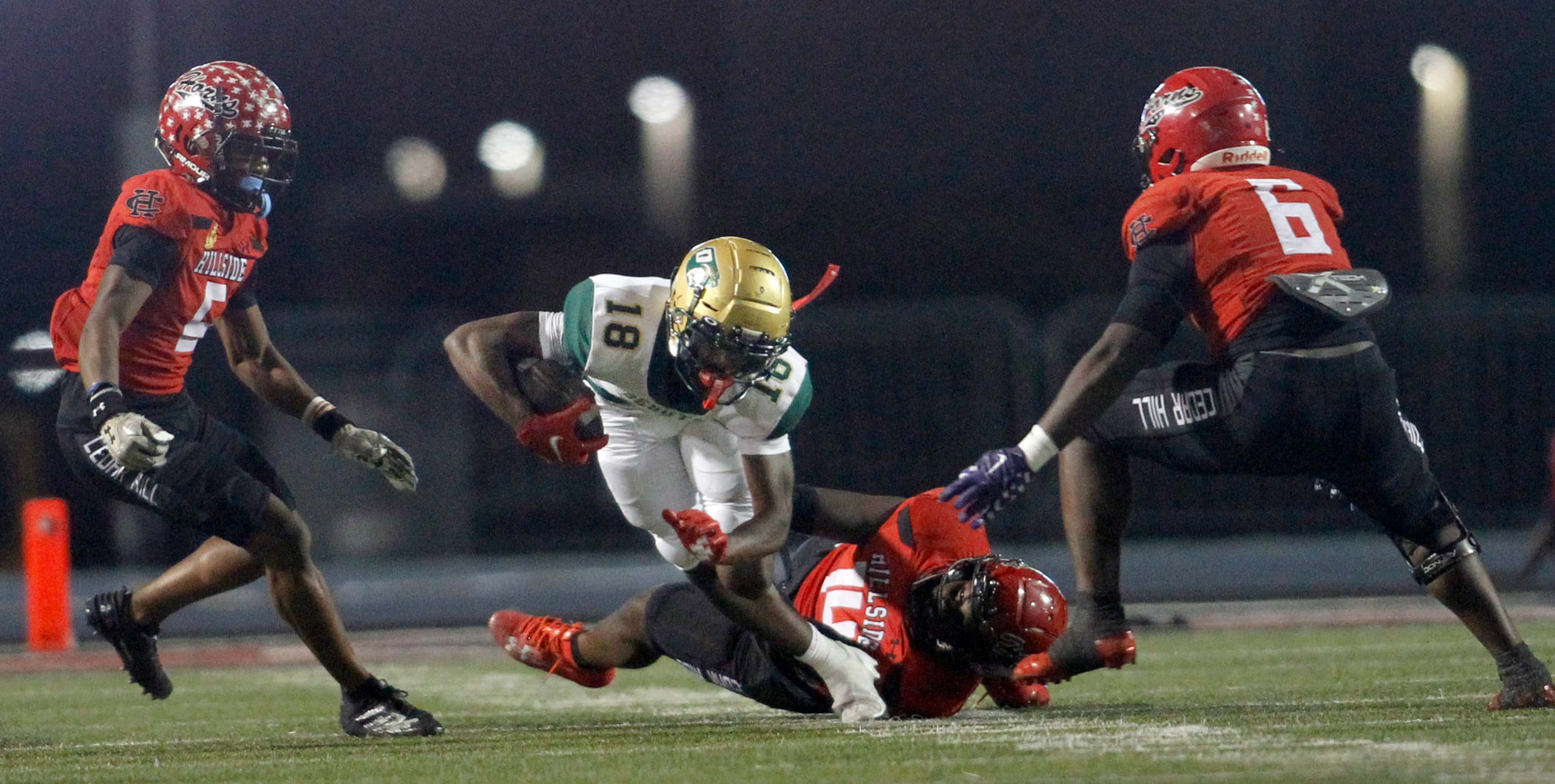 DeSoto receiver Ethan Feaster (18) is tackled by Cedar Hill linebacker Semaj Hervey (14), as...