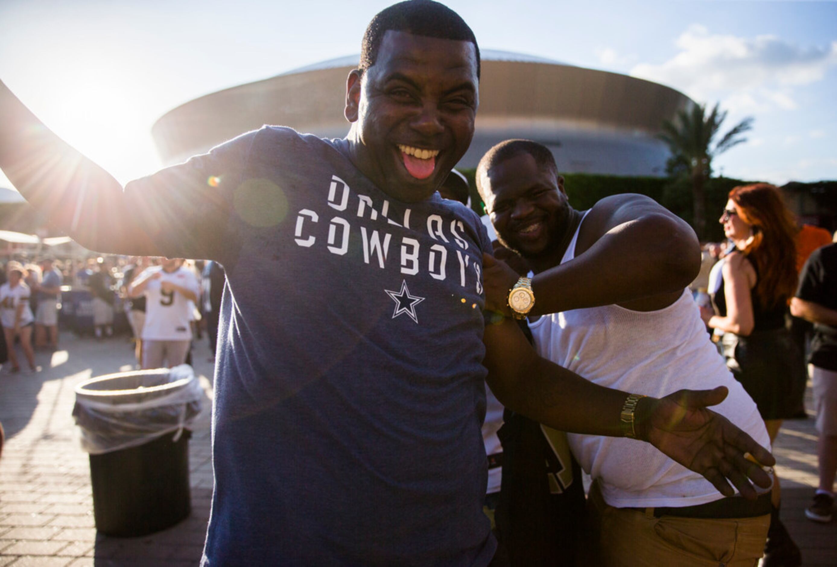 A Dallas Cowboys fan jumps in front of a group photo of New Orleans Saints fans outside the...
