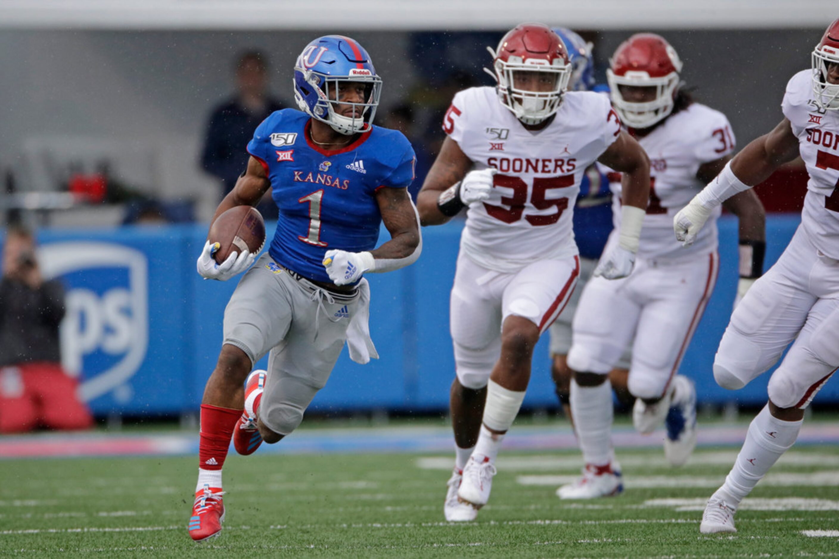 Oklahoma quarterback Jalen Hurts (1) is tackled by Kansas linebacker Kyron Johnson (15)...