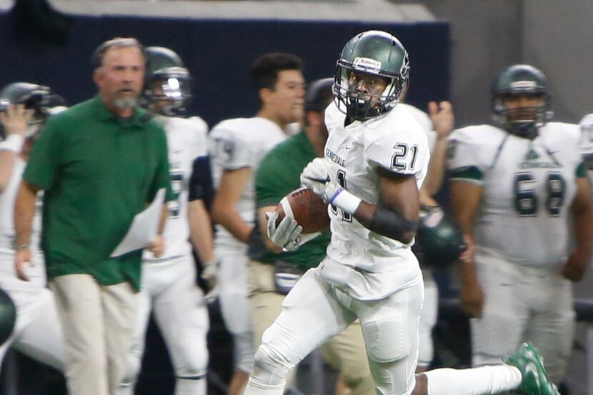 Kennedale special teams player Larry Brooks (21) sprints past head coach Richard Barrett and...