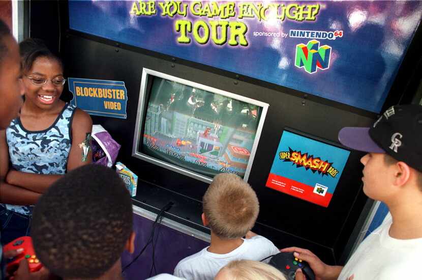 Kay Kay Azubogu, 13, of New Orleans, La. (left) watches some boys play Super Smash Bros. on...