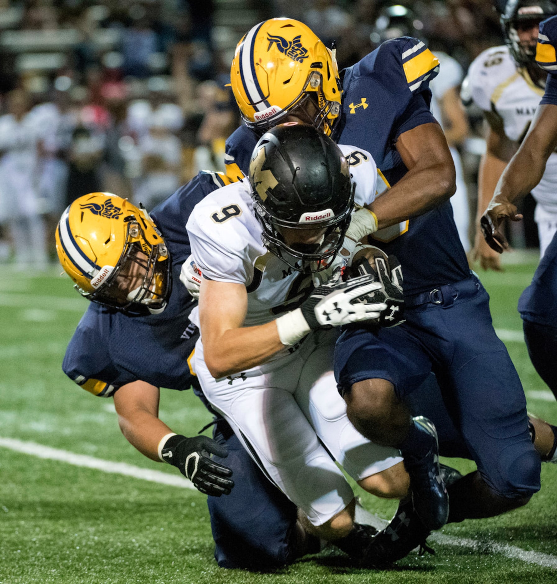 Mansfield senior defensive end Garrett Merryfield (9) is tackled by Arlington Lamar...