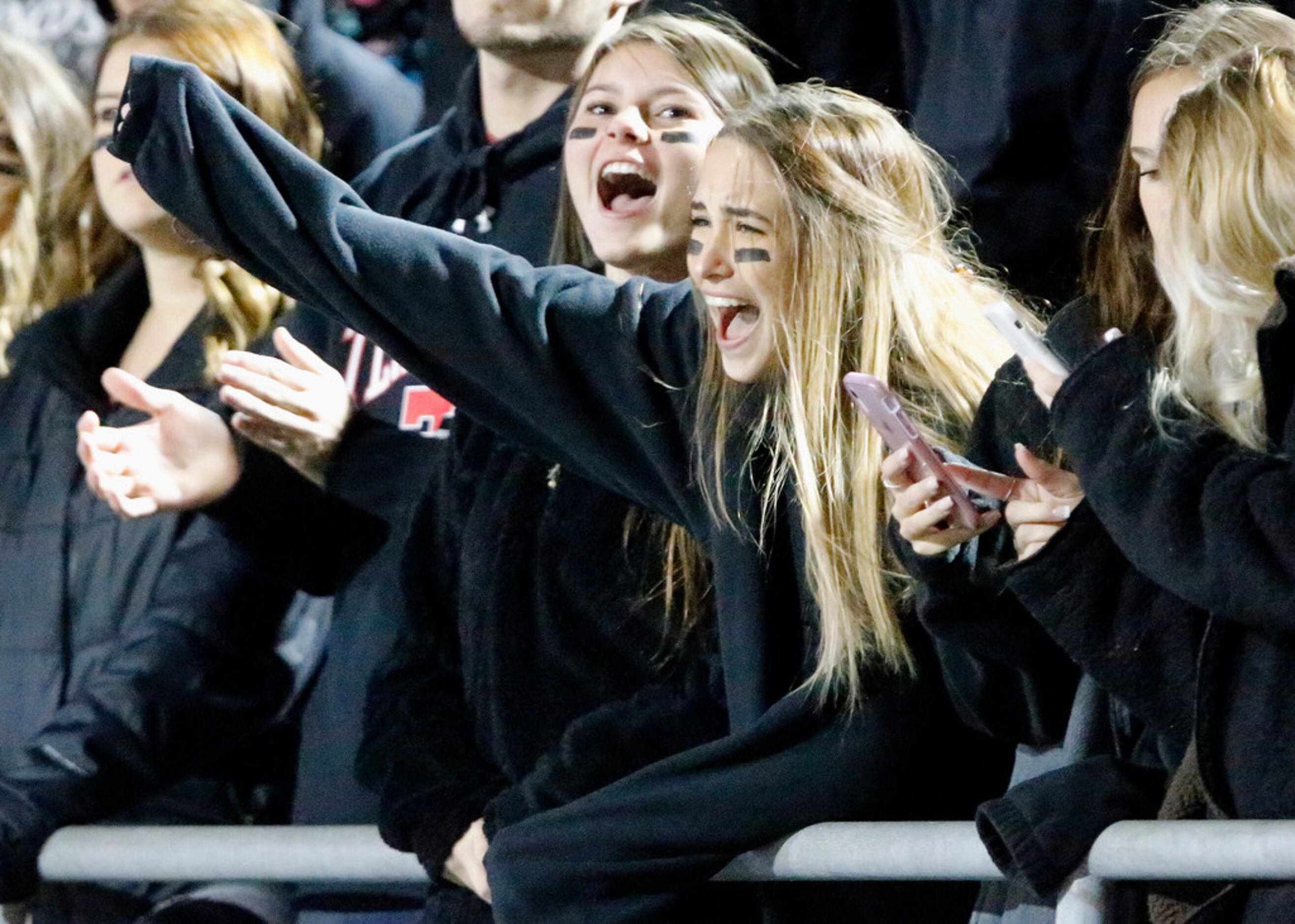 McKinney Boyd High School students Amelia Ziegler (right) and Addi Hogue cheer a score...