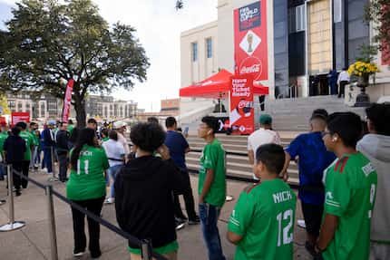 People wait to see the FIFA World Cup trophy on display during the FIFA World Cup™ Trophy...
