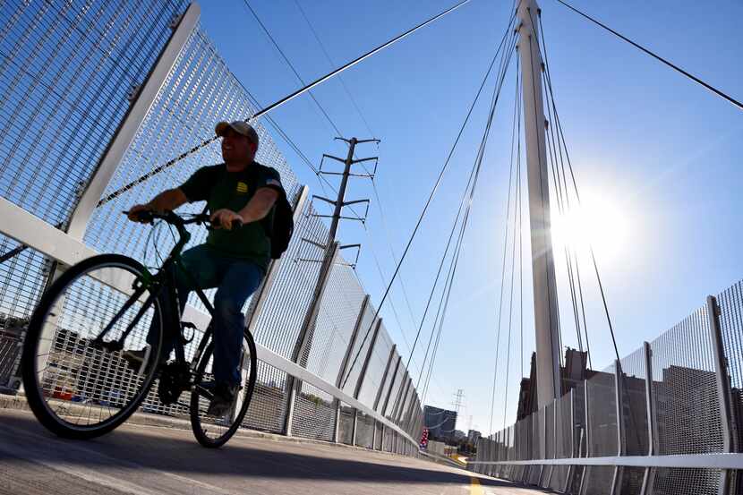 A man rides a bicycle on the new Mockingbird pedestrian bridge over Mockingbird Lane in...