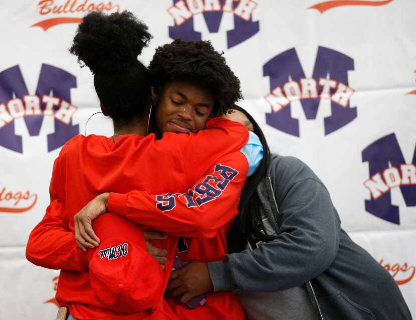 McKinney North wide receiver J.J. Henry gets hugs from his sister Jai-lynn Henry (left) and...