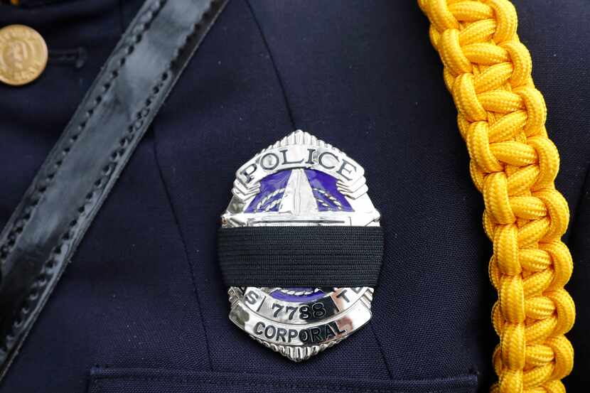 A black mourning band covers the badge of a Dallas police officer honoring slain Richardson...