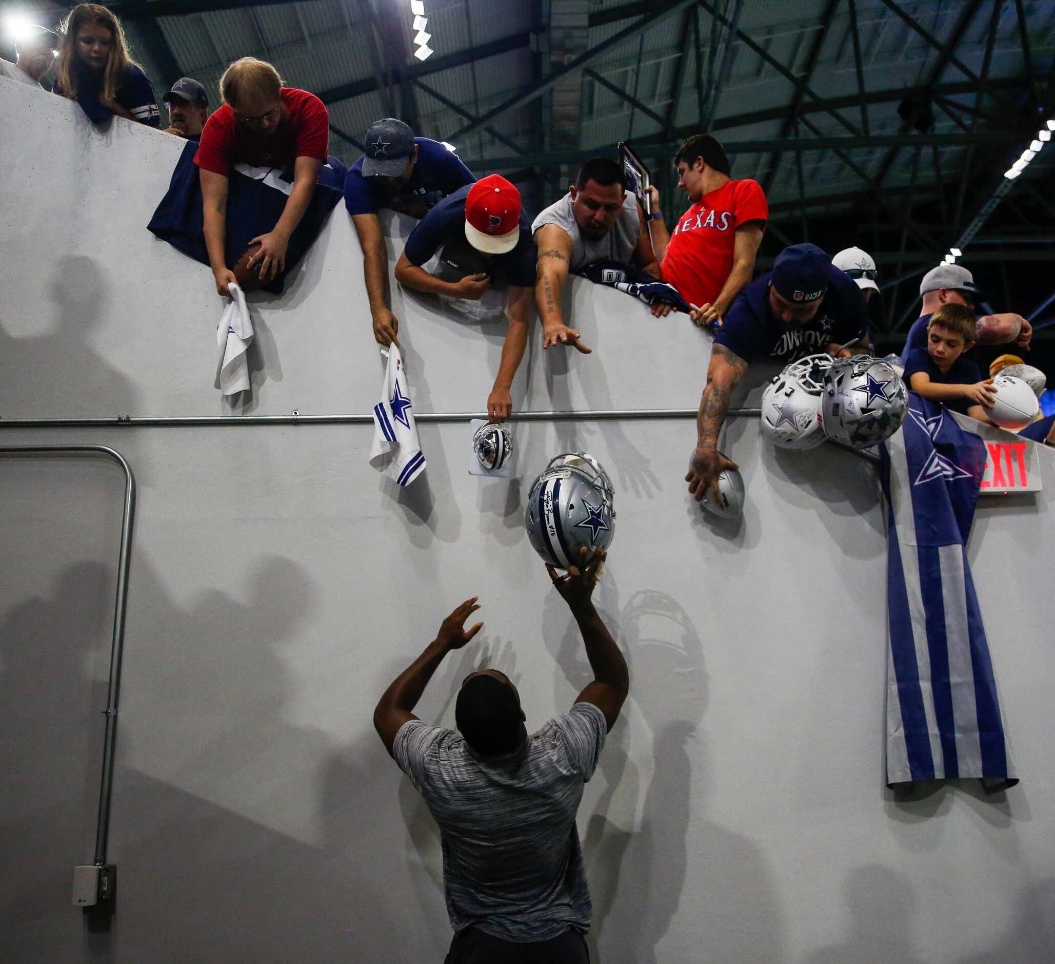 Fans reach for autographs from wide receiver Amari Cooper during a Dallas Cowboys practice...