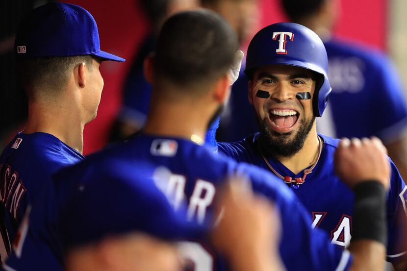 ANAHEIM, CA - AUGUST 23:  Robinson Chirinos #61 of the Texas Rangers is congratulated in the...