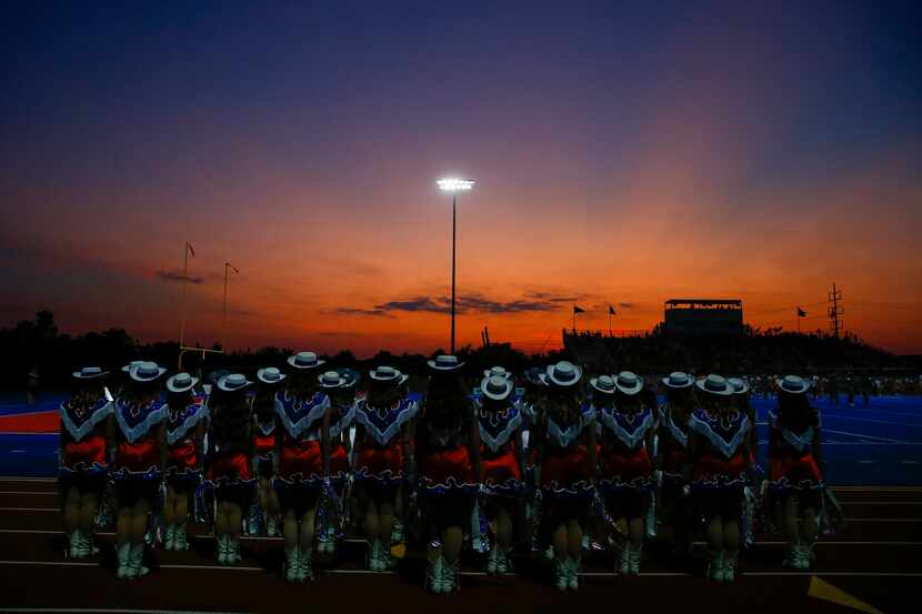 The sun sets beyond the Parish Episcopal drill team during a high school football game...