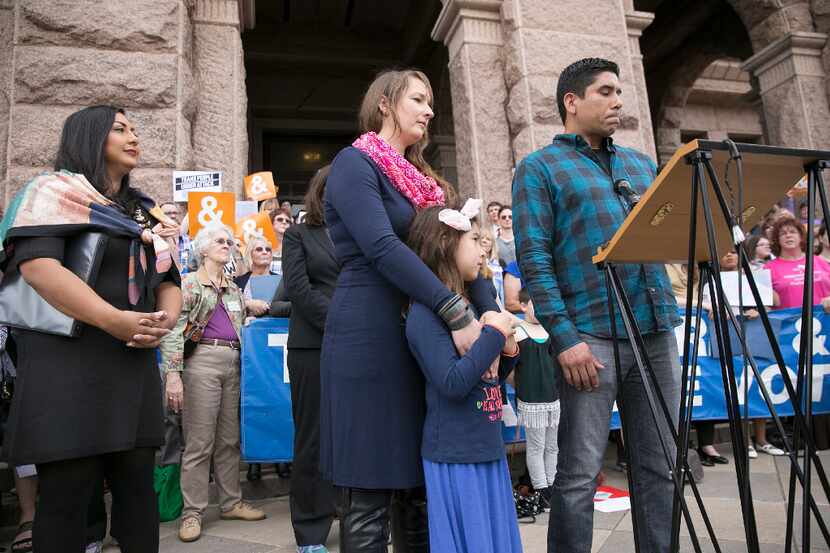 Frank Gonzales, front right, speaks about his daughter, Libby, 6, center, a transgendered...