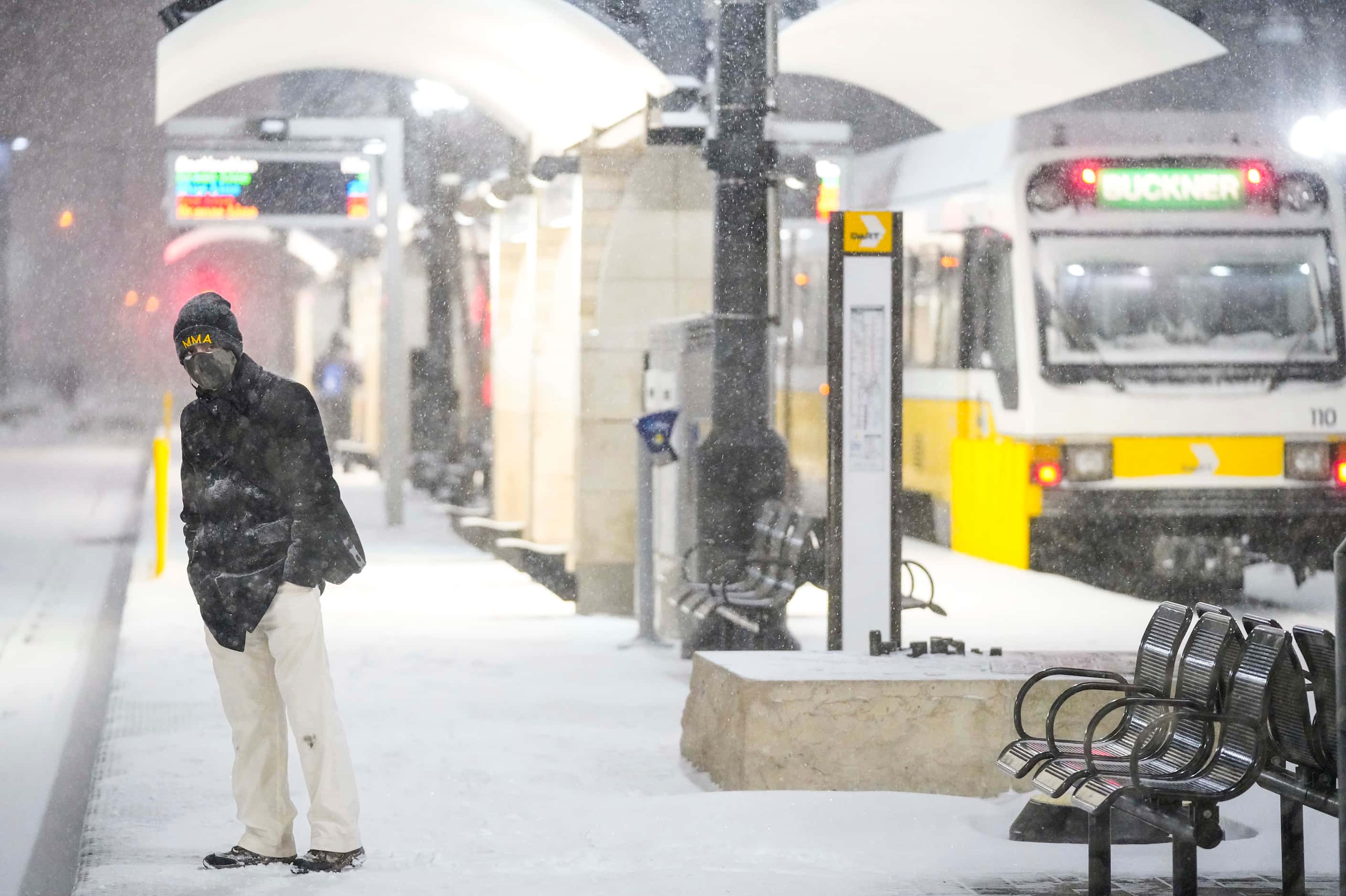 Victor Escamilla looks down the tracks as people wait in driving snow at the Pearl/Arts...