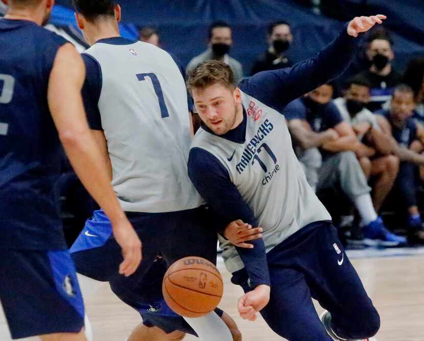 Dallas Mavericks guard Luka Doncic (77) slips behind a screen from Dallas Mavericks center...