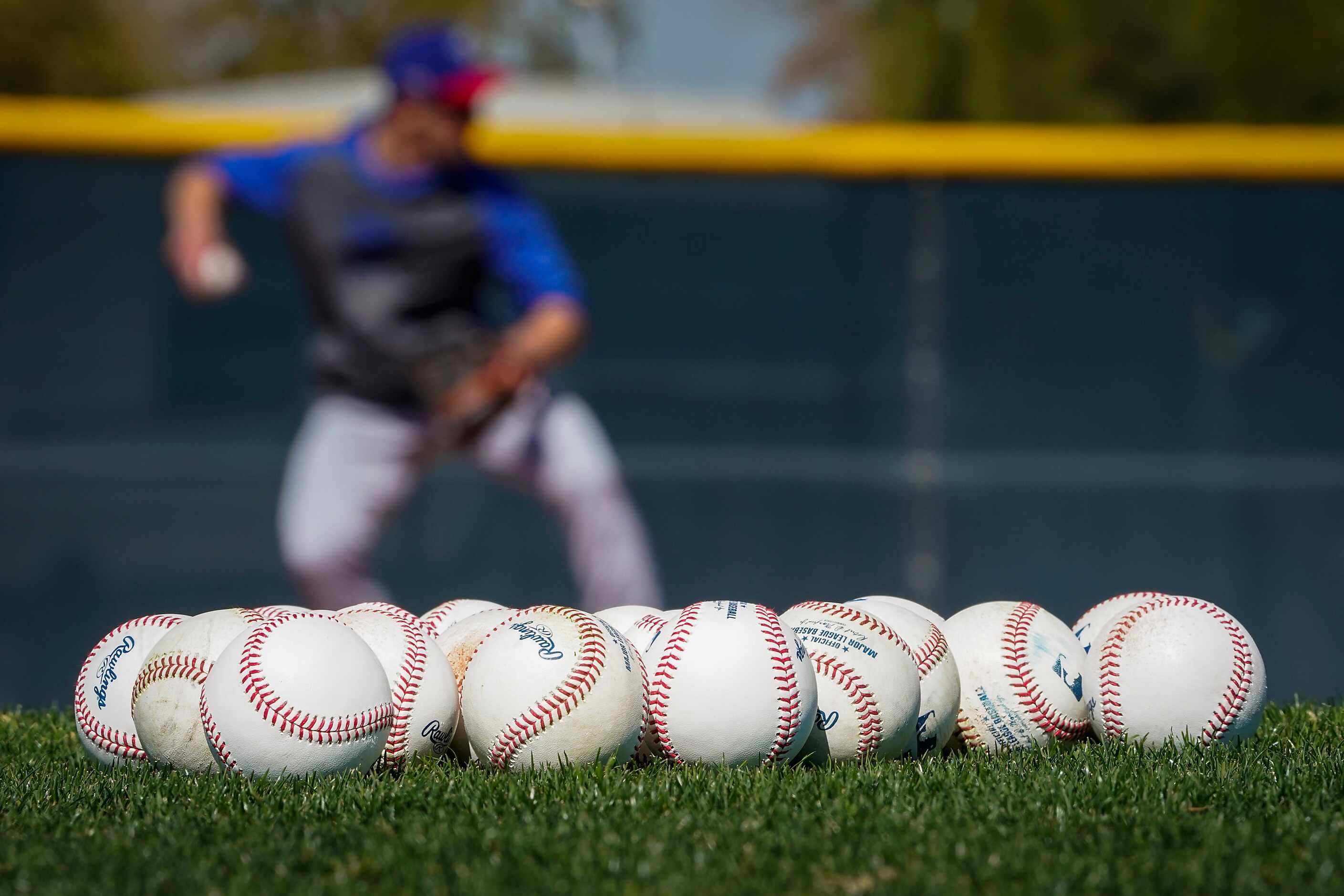 Texas Rangers infielder Eli White takes grounders at shortstop during an informal workout...