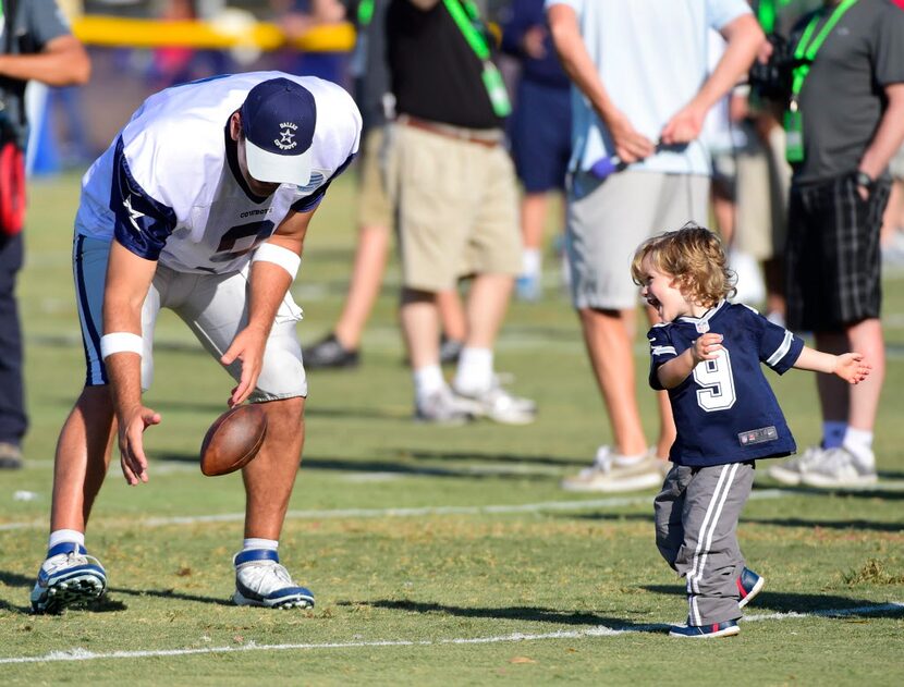 Tony Romo plays with his son, Hawkins, after the afternoon practice at Dallas Cowboys...