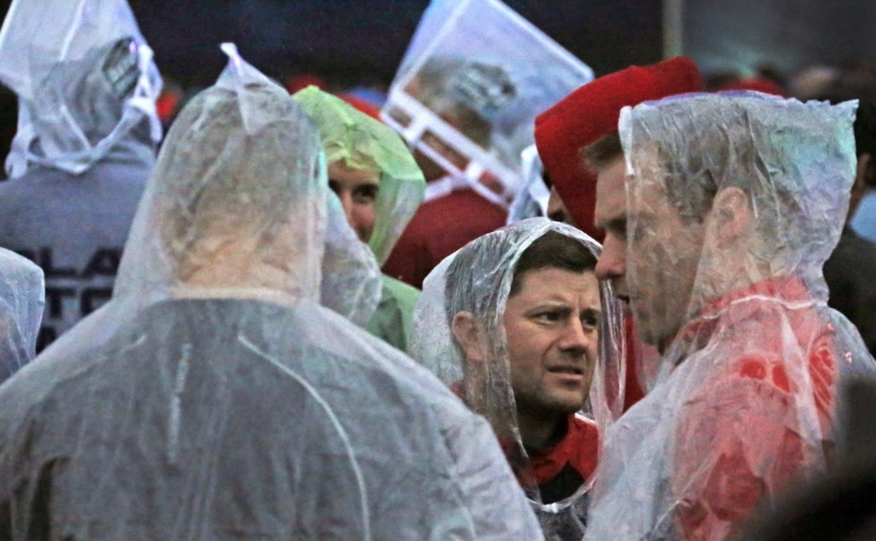 Fans try to stay dry as they wait for Bruce Springsteen to perform during the March Madness...