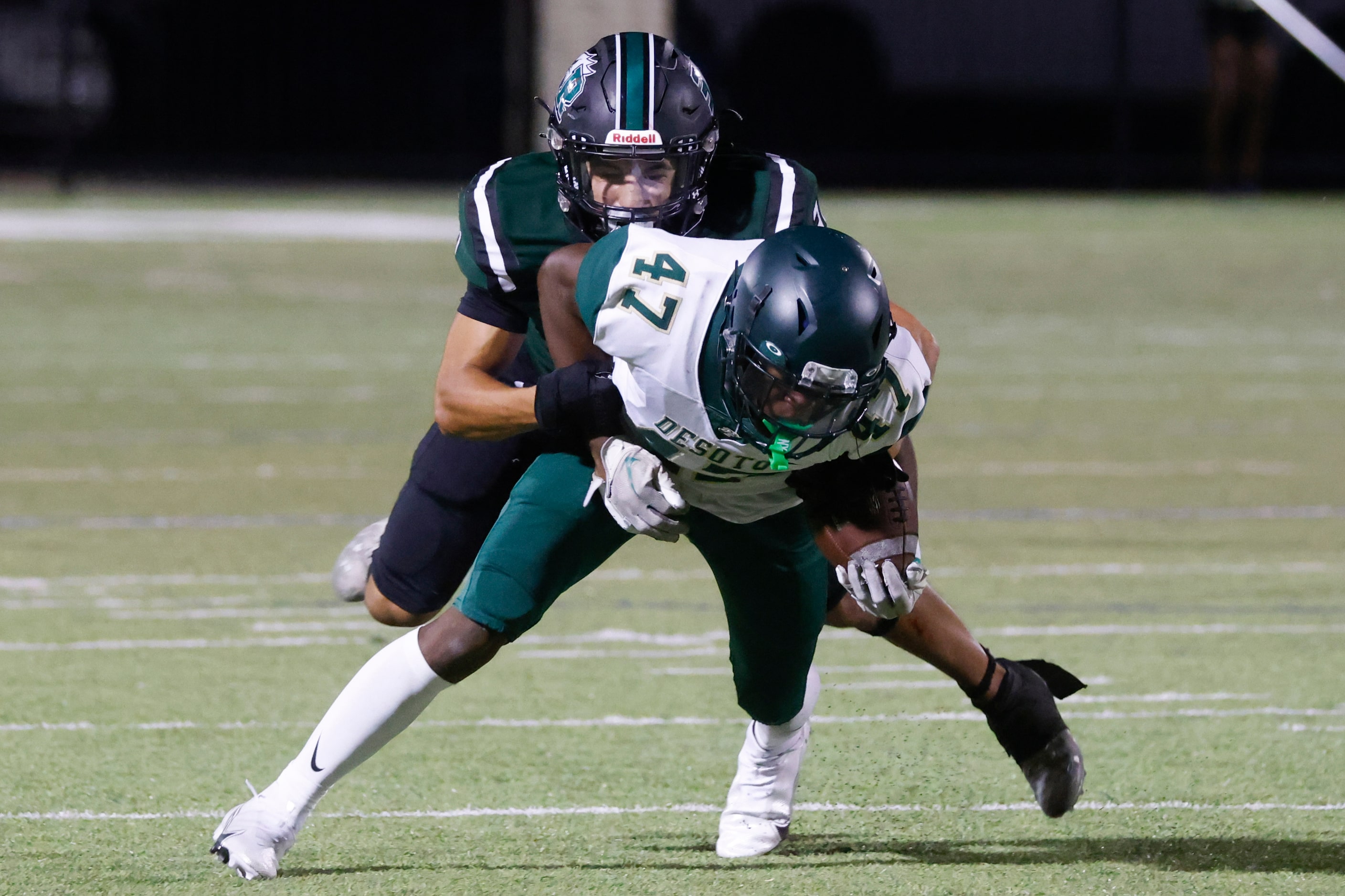 Lake Ridge High’s Matthew Martinez (31), back, tackles DeSoto High’s Jaylin Jones (47)...