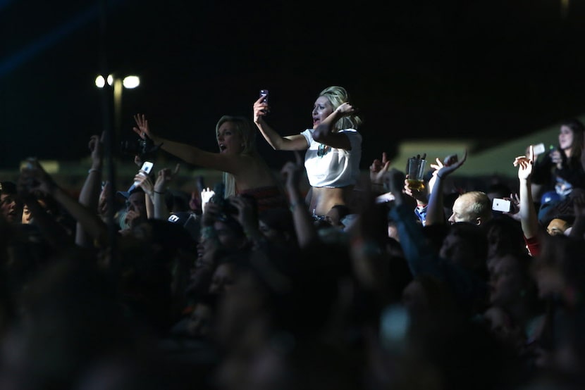 Fans cheer as they listen to Jason Aldean live onstage at the 2014 NCAA March Madness Music...