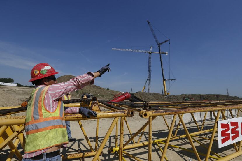Workers build up a crane at the construction site of the Irving Music Factory at Las...