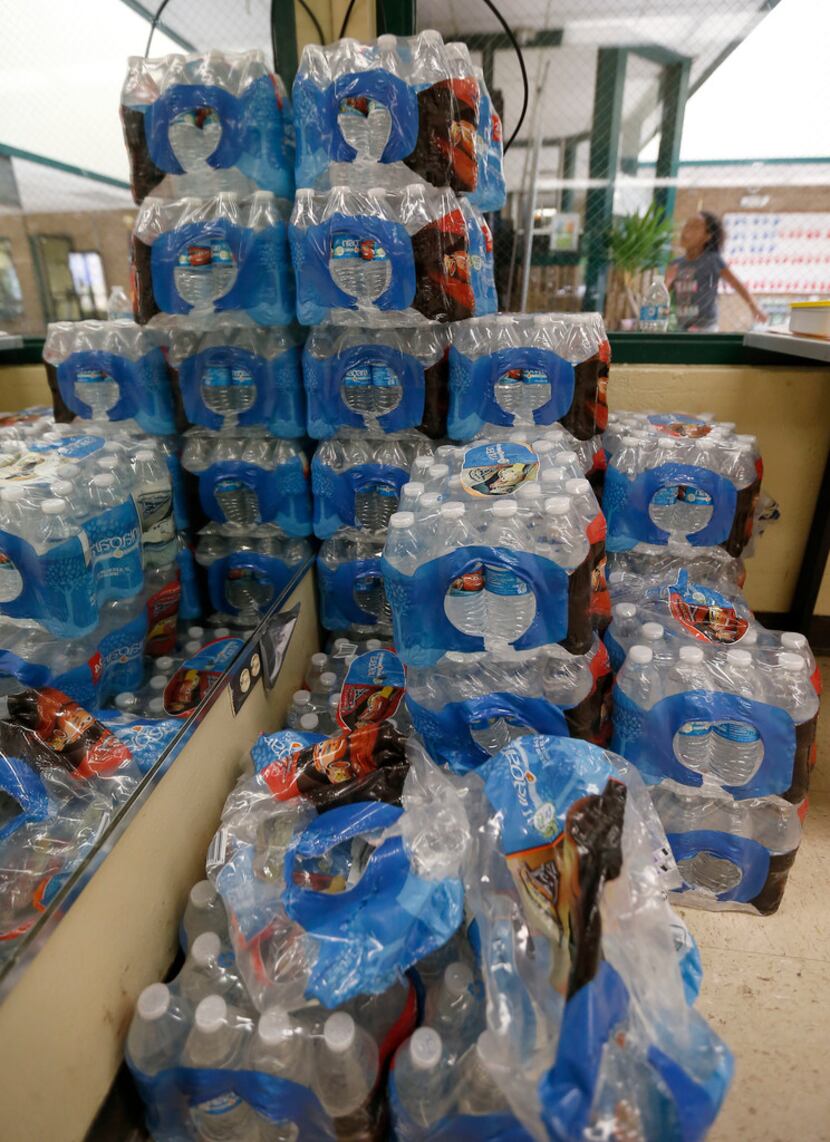Bottles of water are stacked high in a cooling center at Reverchon Recreation Center in...