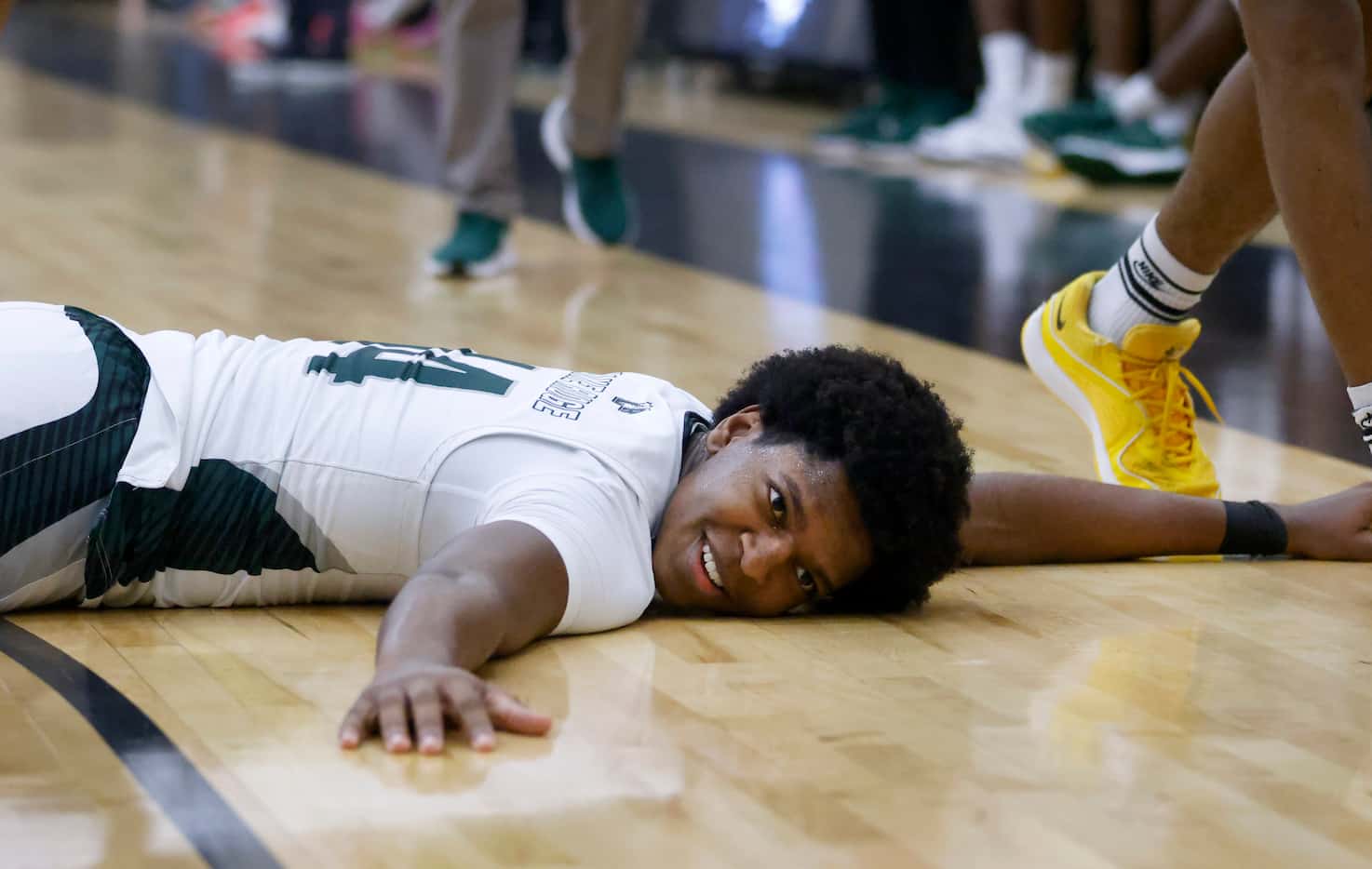 Mansfield Lake Ridge’s DeMarcus White (14) lies flat on the court after he tried to steal...
