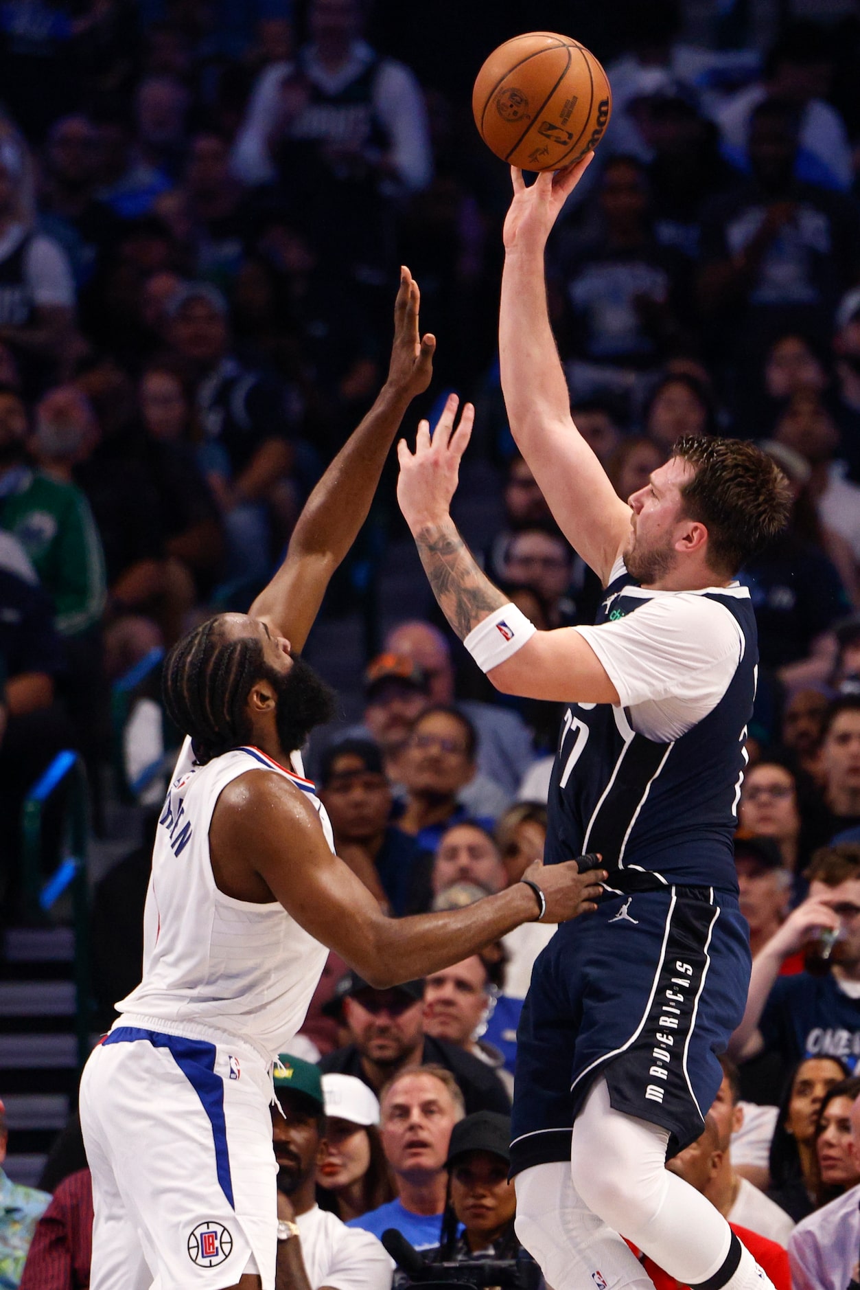 Dallas Mavericks guard Luka Doncic (77) shoots the ball over LA Clippers guard James Harden...