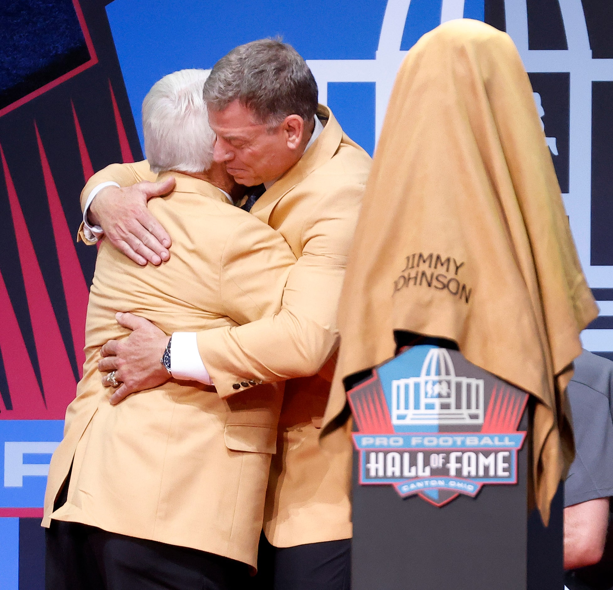 Pro Football Hall of Fame inductee Jimmy Johnson of the Dallas Cowboys (left) receives a hug...