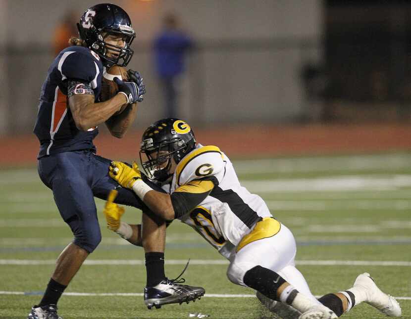 Sachse Mustangs WR Bruce Brookins (6) hauls in a catch in front of Garland Owls DB Drashane...