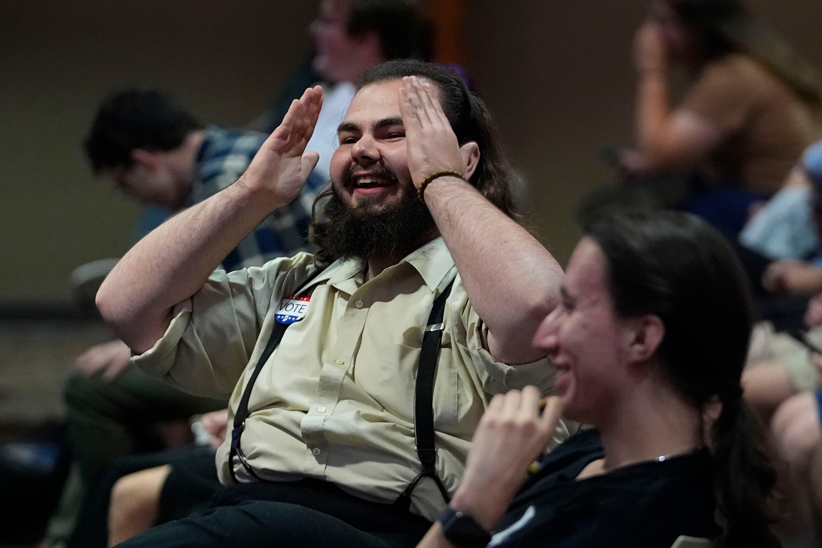 Luther Henderson laughs as he watches the presidential debate between Republican...