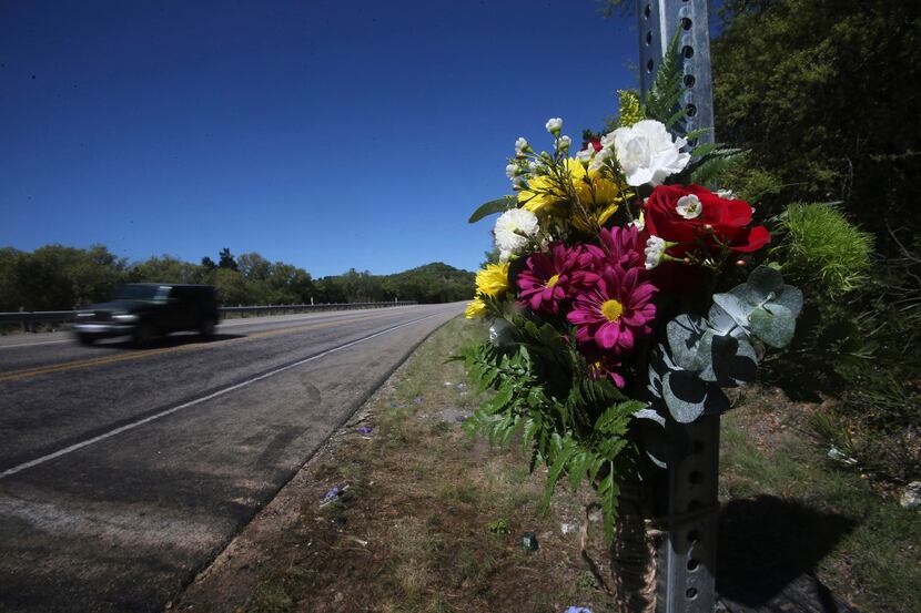 Flowers are placed on a road sign where 13 people died in Wednesday's head-on collision...