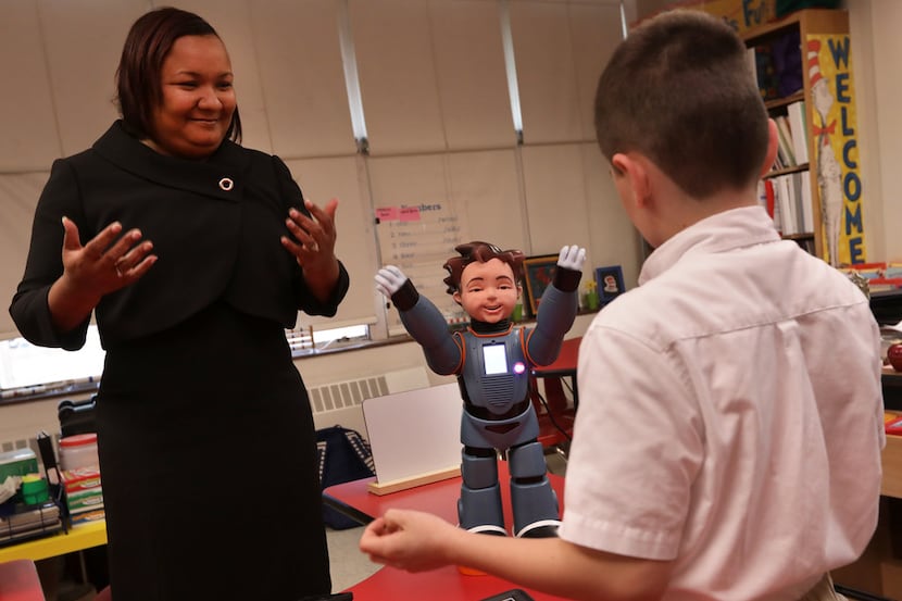 Karol Henderson (left)  and 7-year-old Maxwell Cowles dance with Milo the interactive robot...