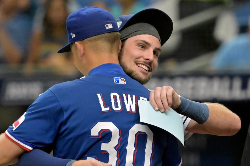 Tampa Bay Rays' Josh Lowe, right, hugs his brother Texas Rangers' Nathaniel Lowe (30) after...