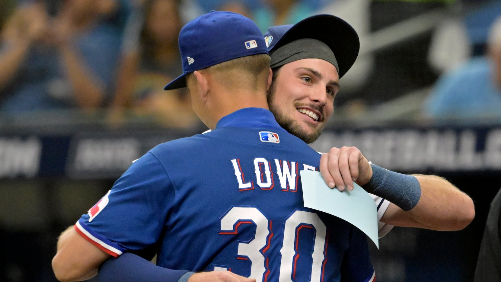 Tampa Bay Rays' Josh Lowe, right, hugs his brother Texas Rangers' Nathaniel Lowe (30) after...