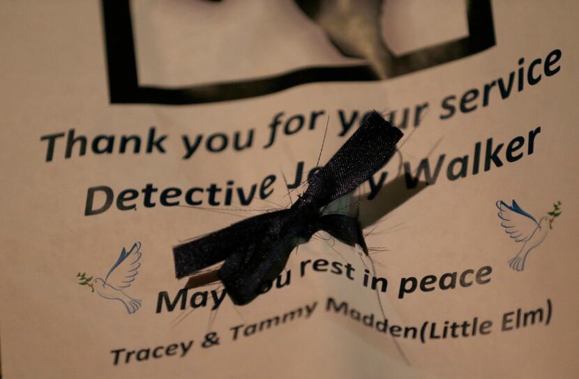 A note with a black ribbon is seen during a vigil for Det. Jerry Walker at Little Elm Park...