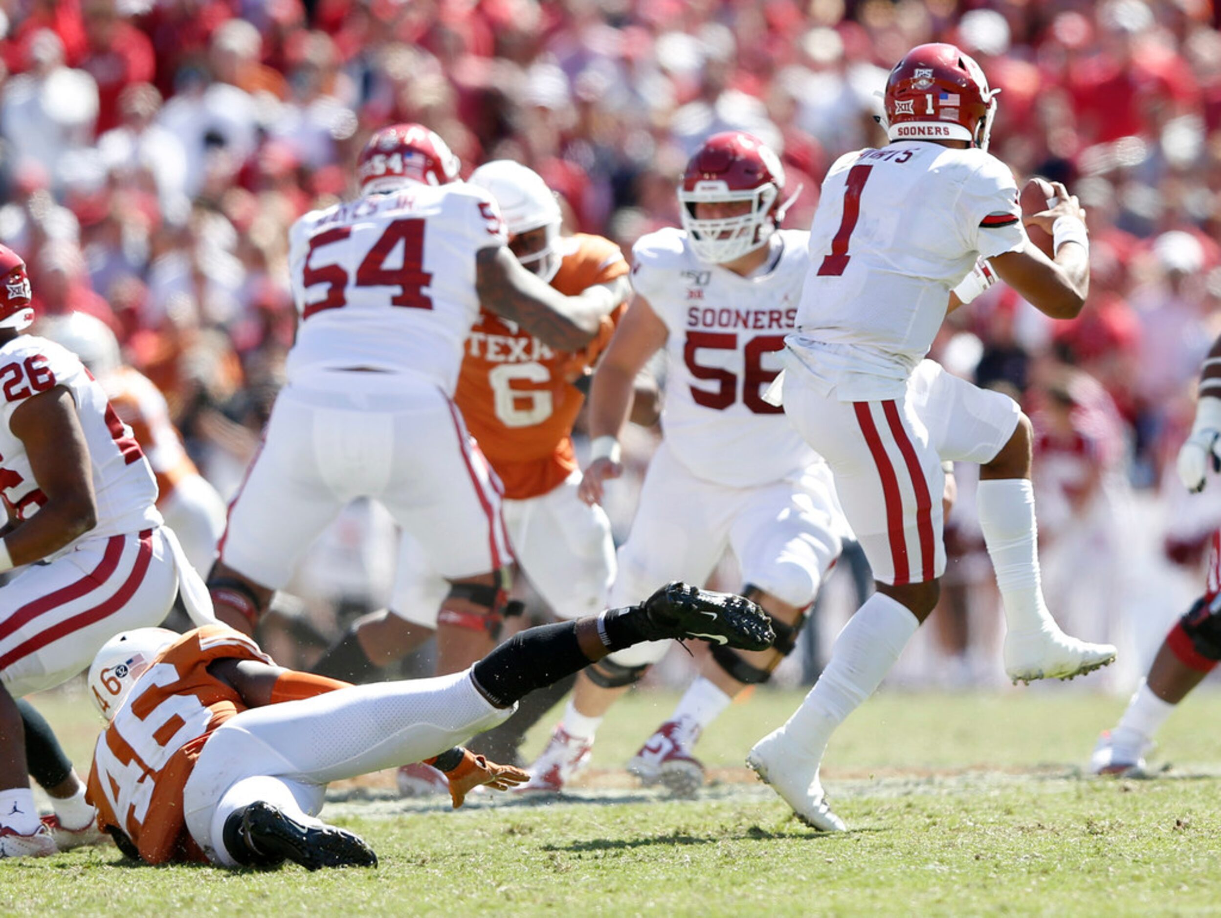 Oklahoma Sooners quarterback Jalen Hurts (1) escapes a rushing Texas Longhorns linebacker...