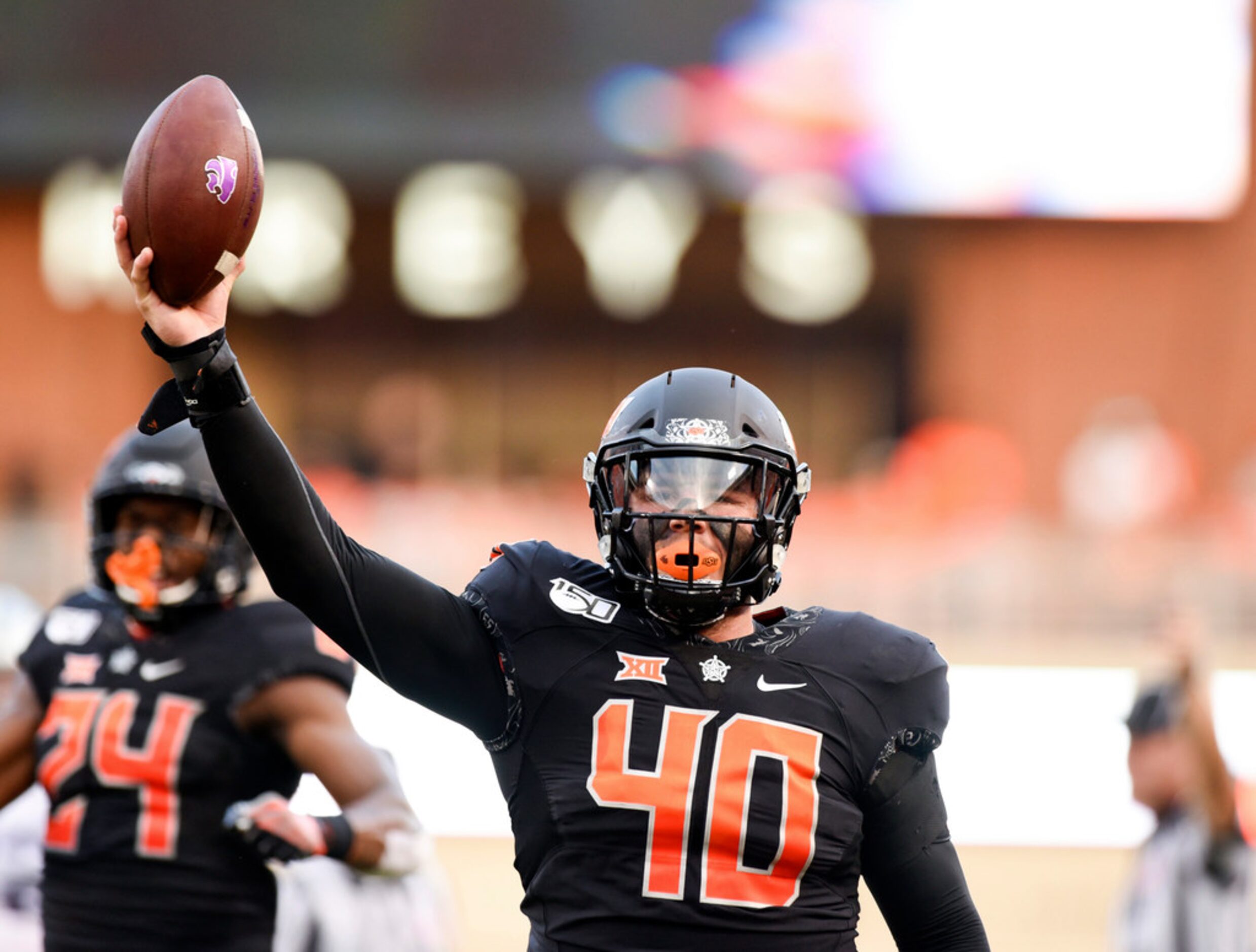 In celebration, Oklahoma State defensive lineman Brock Martin holds up the football he...