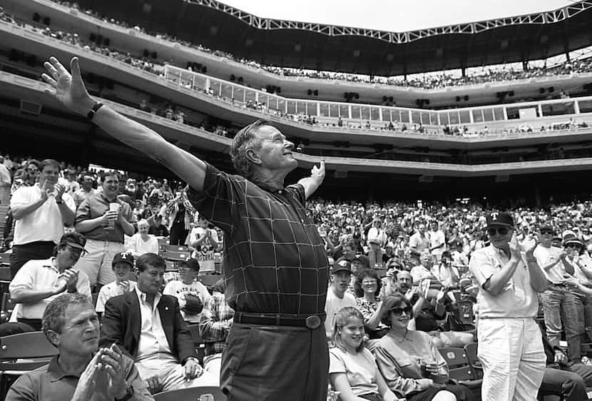 1994: Former Pres. George Bush acknowledges fans' cheers at The Ballpark in Arlington before...