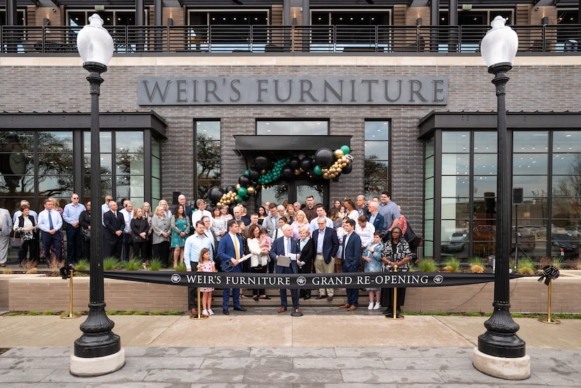 Mark Moore, CEO of Weir's Furniture, and his mother, Patsy Weir Moore, prepare to cut the...