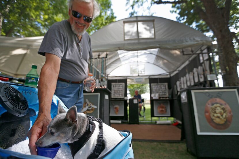 Emmett McCanlies gave water to his dog Rocco while walking at the Art on the Greene festival...