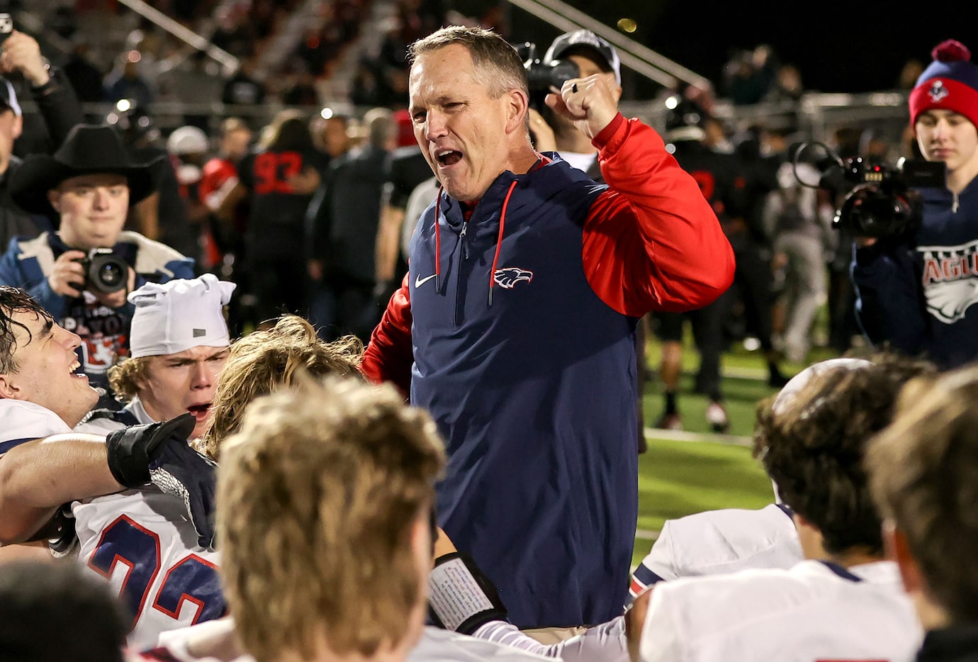 Allen head coach Kee Wiginton celebrates with his team after defeating Euless Trinity, 22-21...